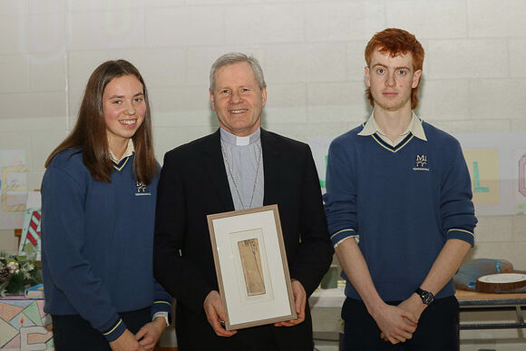 Bishop Fintan receives a gift from Co-chairs of Student Council Ciara Galvin and John Smith at MICC