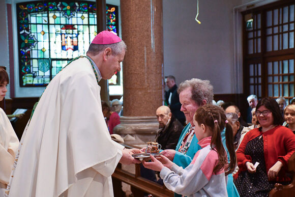 Bishop Fintan Gavin accepting the gifts of bread and wine from Mary and Barbora Veale during  Mass