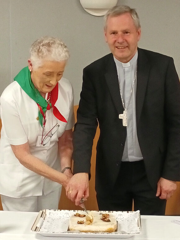 Bishop Fintan helps Deirdre cut the social cake